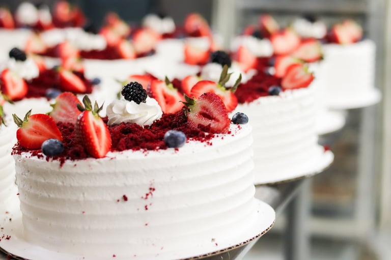 Elegant red velvet cake with fresh berries and whipped frosting