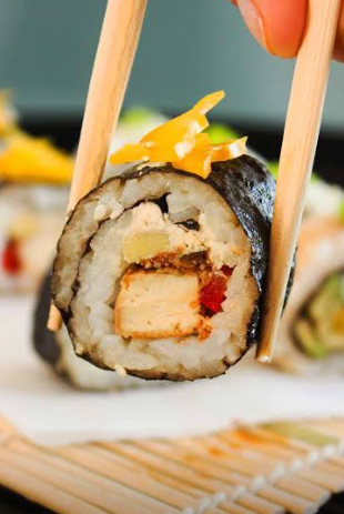 Close-up of sushi roll held with chopsticks